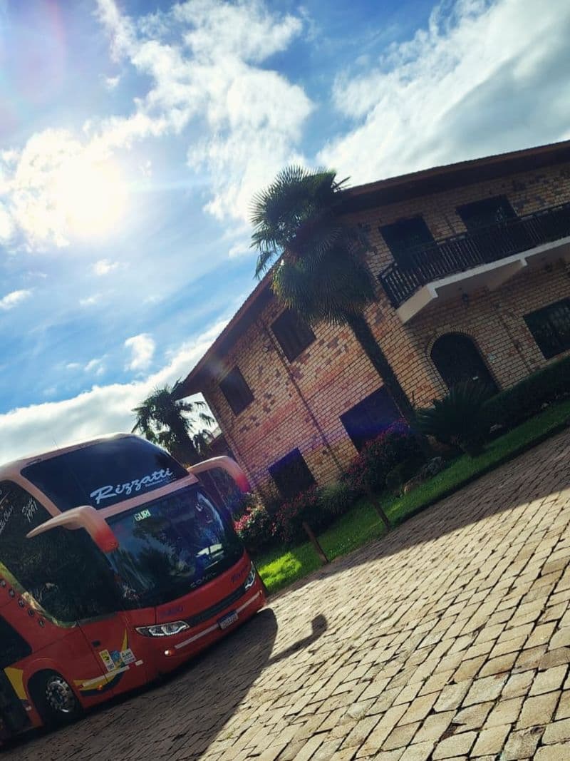 Ônibus Rizzatti estacionado em pousada na serra em dia de sol