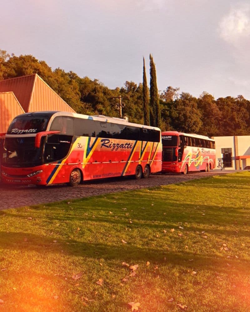 Dois ônibus Rizzatti enfileirados ao entardecer durante uma viagem